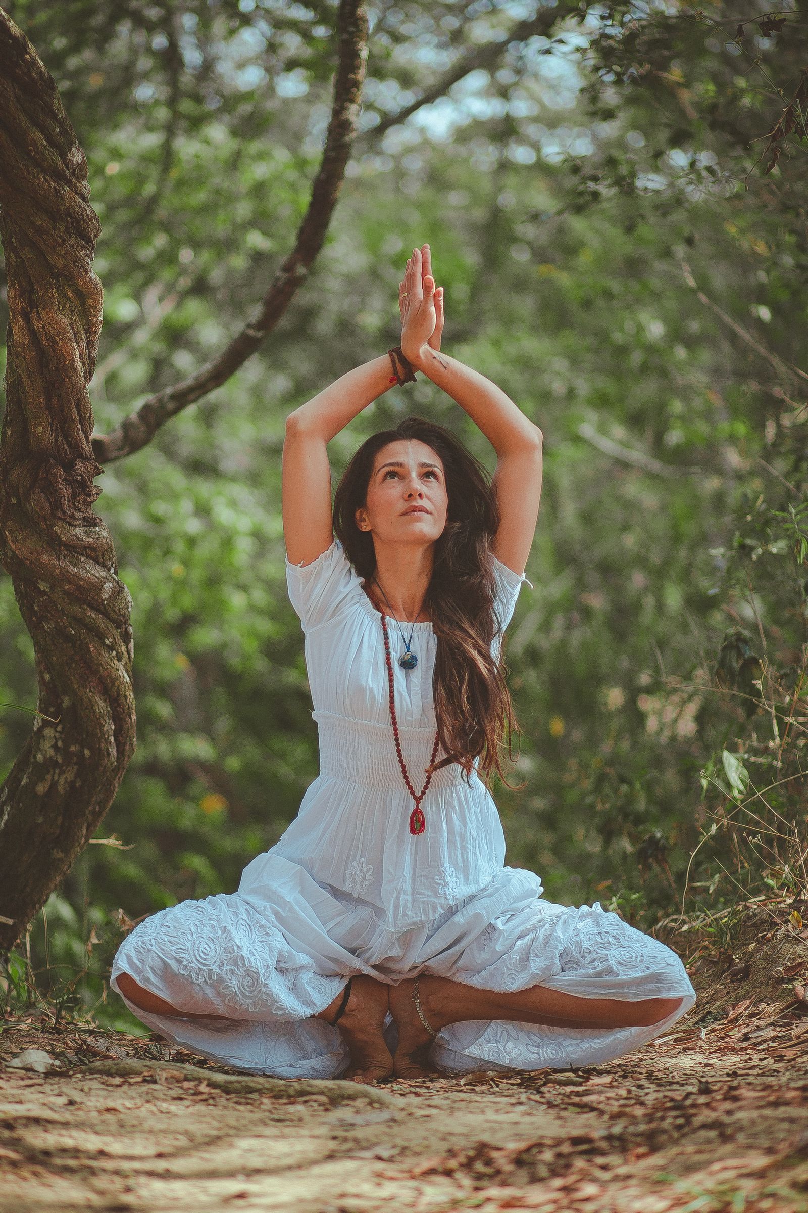 A practitioner in a kundalini yoga teacher training meditating with hands raised