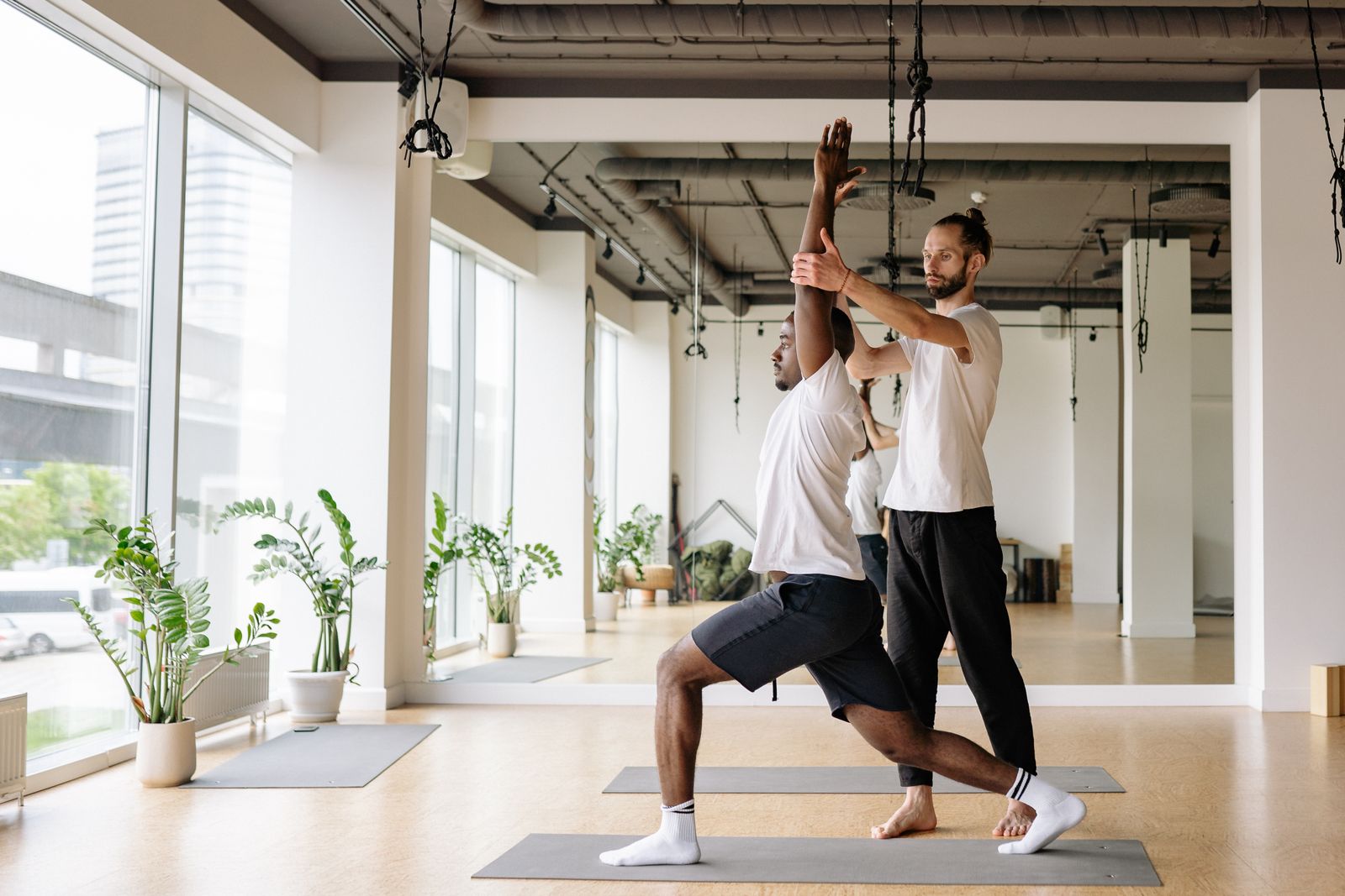 A teacher guiding students, showing how to become a yoga instructor