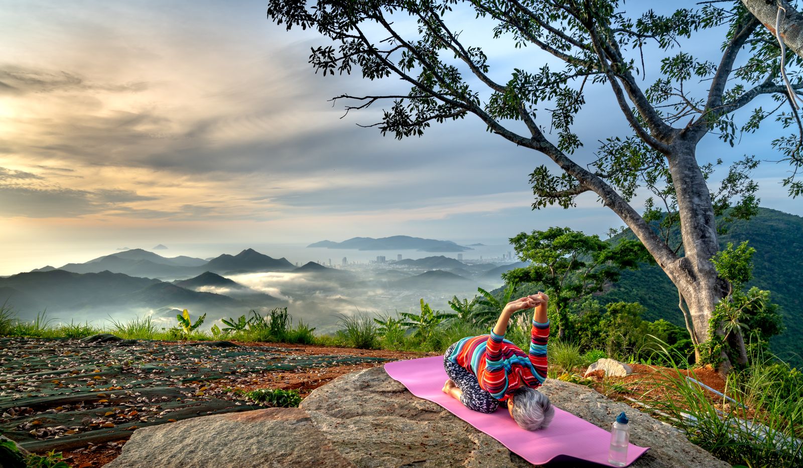 A woman practising yoga in the mountains, on a solo female yoga teacher training in Rishikesh